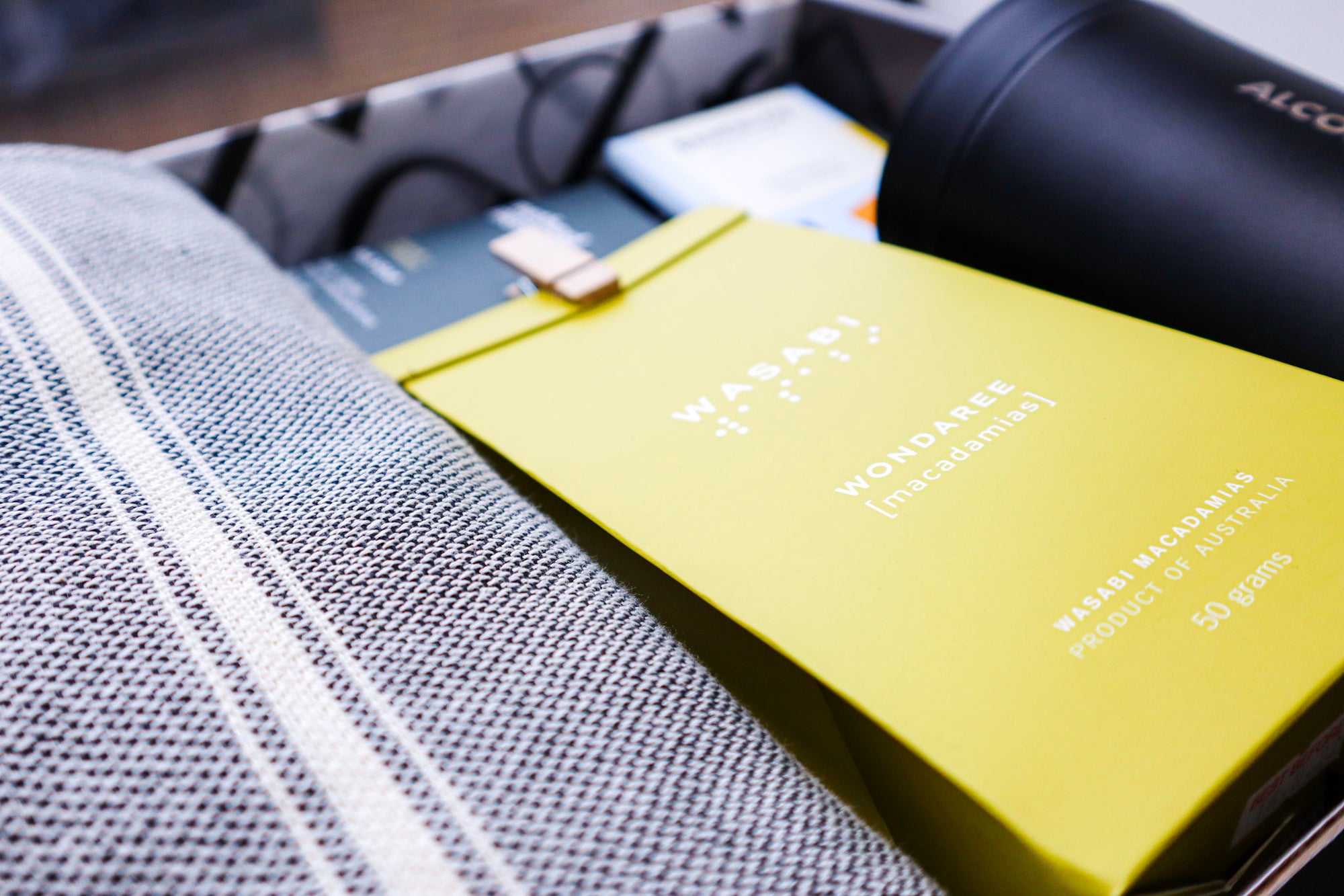 Yellow pack of Wondaree Wasabi Madacamias with a cute timber peg on the top of the pack