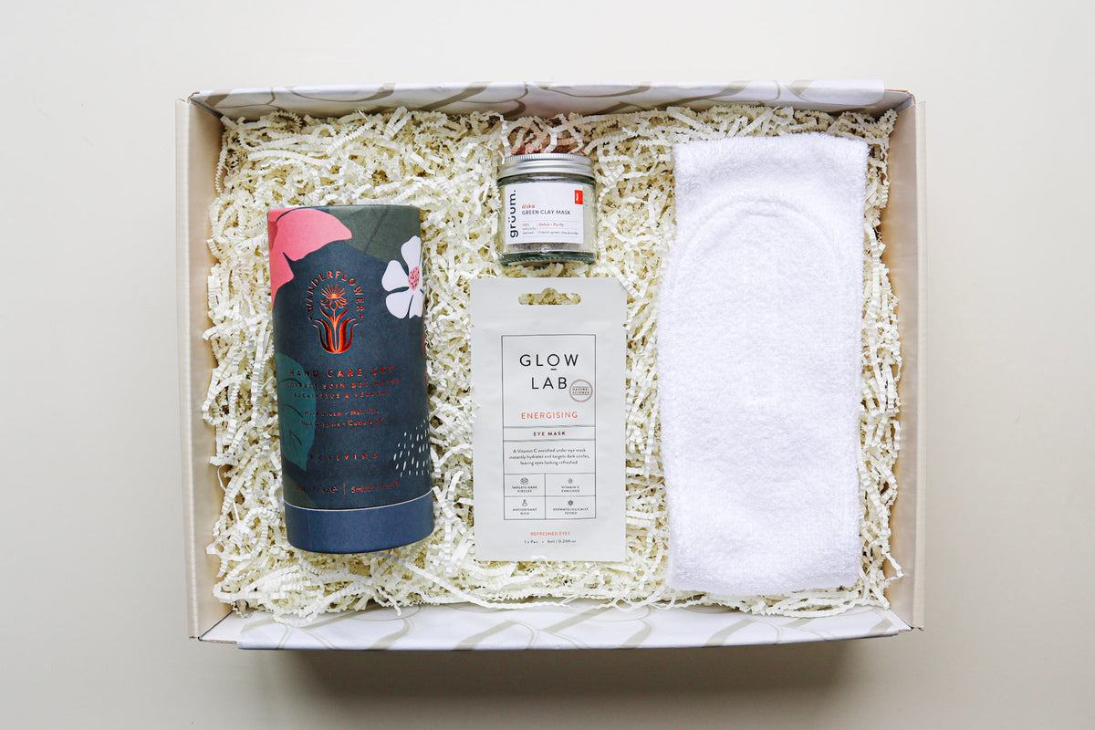 Pamper Me Giftbox is a cream box containing a Wanderflower Hand Care Set, a Glow Lab Eye Mask, Gruum Green Clay Mask in a cute jar, and a White Headband
