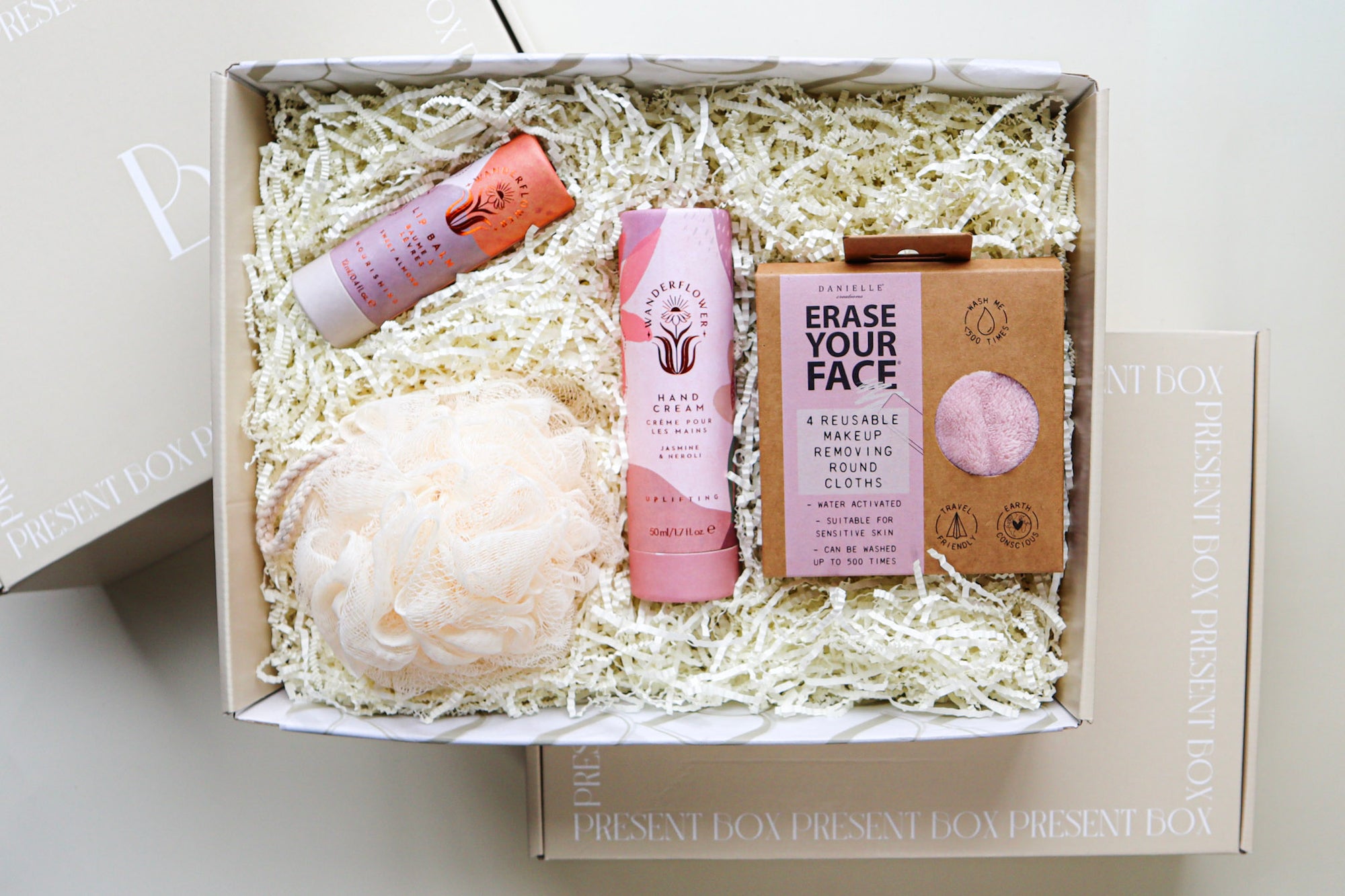 Revive Gift Box contains pink coordinated items including a Wanderflower Handcream and Lip Balm, a pack of 4 Erase Your Face Reuseable Make Up Removing Round Cloths and a Cream Bath Exfoliating Puff