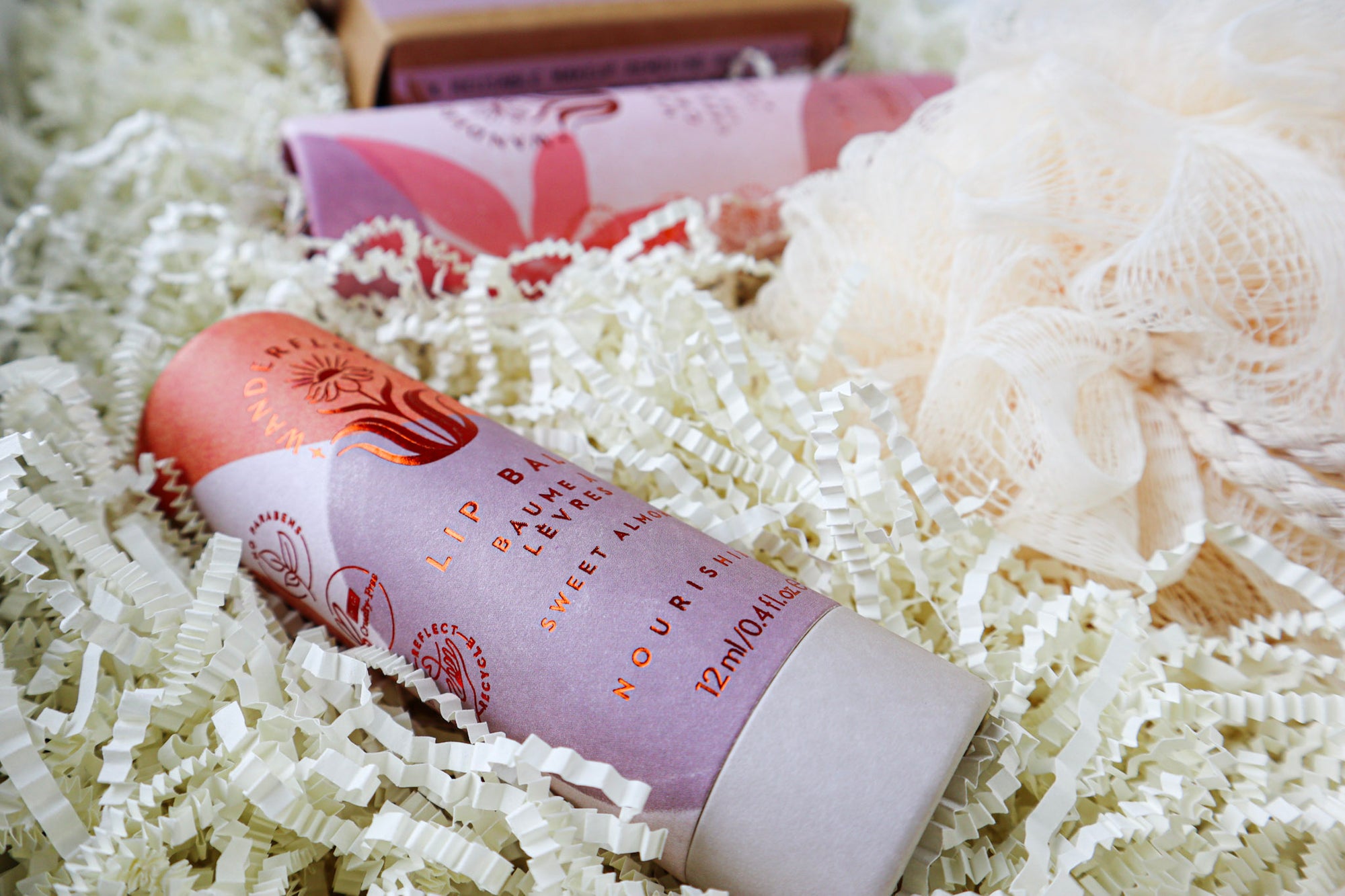 Close up of pink and white coloured paper tube containing Wanderflower Lip Balm