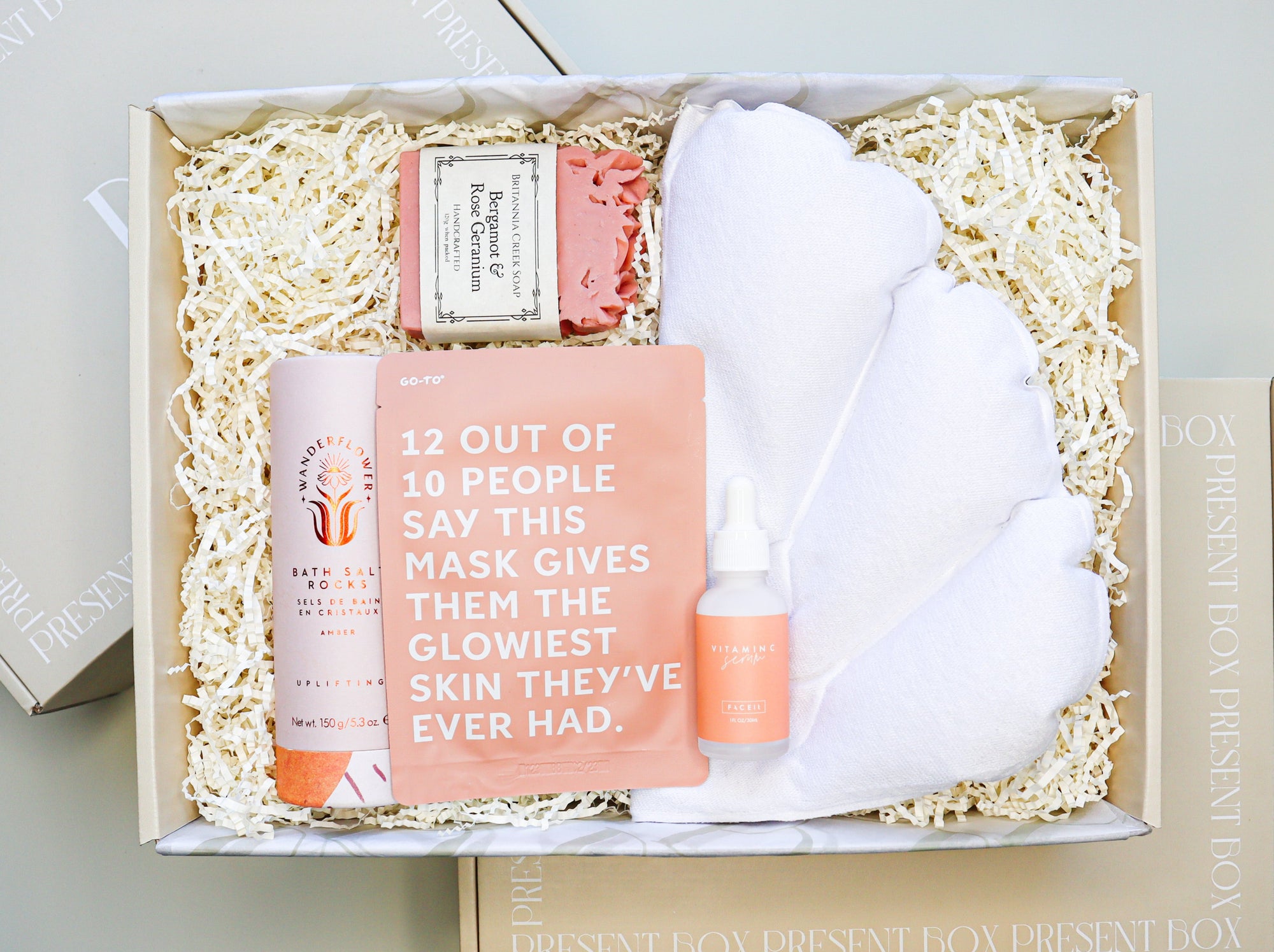 Bath Time Gift Box is a cream box filled with Wanderflower Bath Salt Rocks, Brittania Creek Bergamot & Rose Geranium Soap, a Go-To Face Mask, Face It Vitamin C Serum and a shell shaped inflatable bath pillow